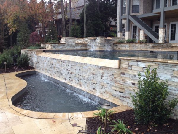 A modern stacked stone vanishing edge pool with clean lines and luxurious finishes.