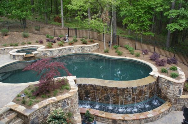 A sleek modern stone vanishing edge pool blending seamlessly with its surroundings.