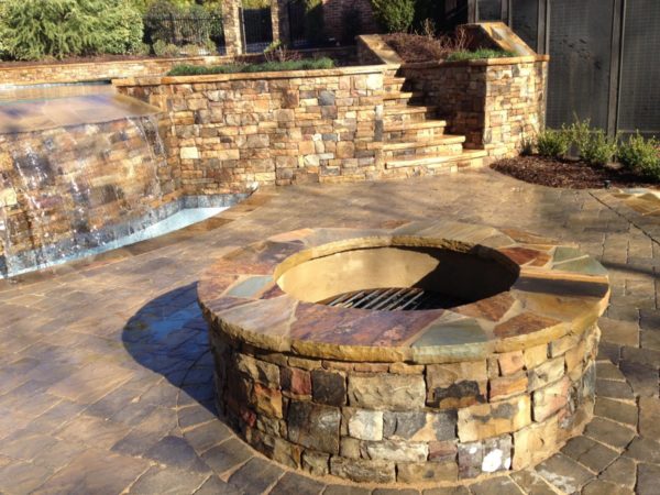 A cozy fire pit surrounded by comfortable seating, offering a warm and inviting retreat by the pool.