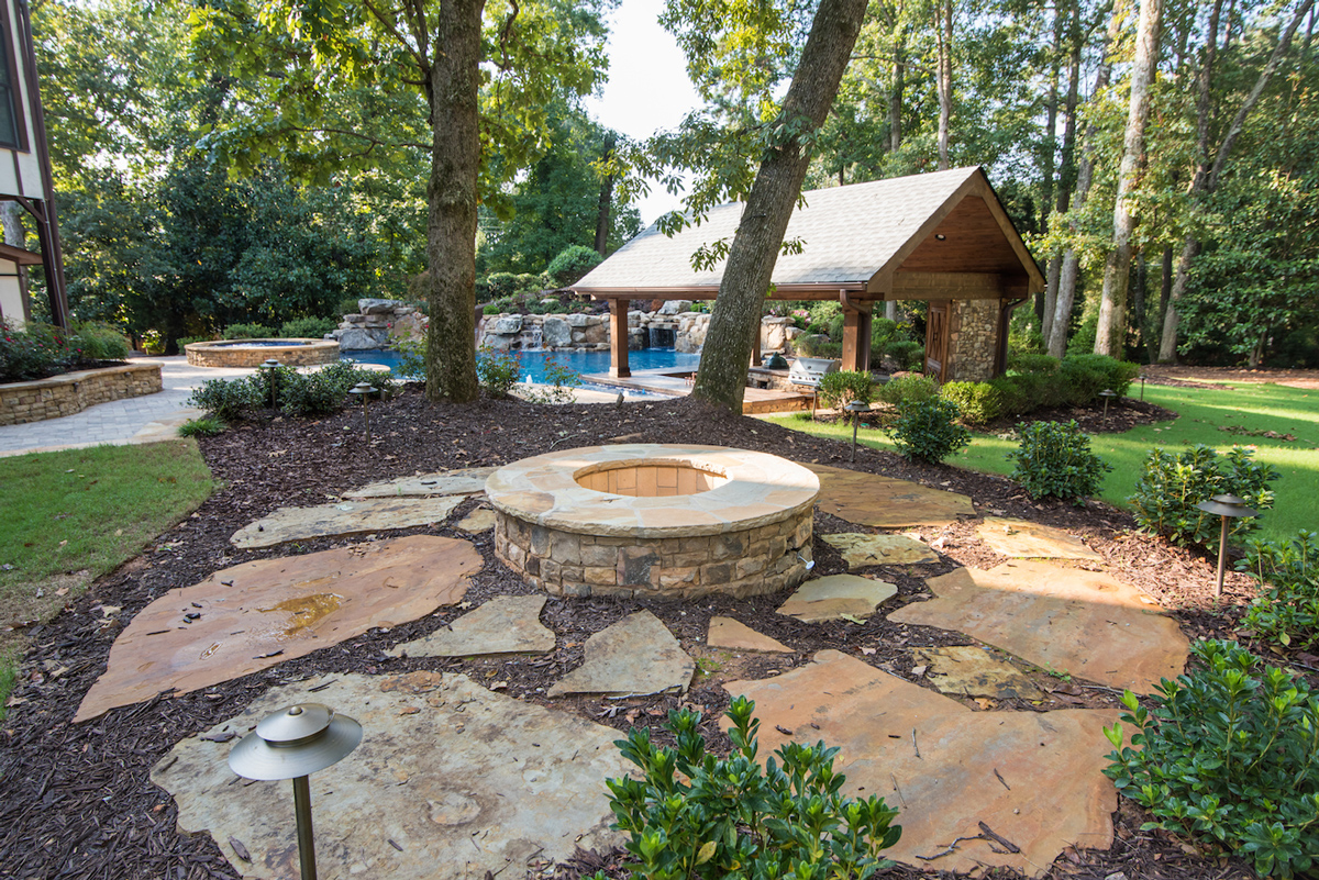 A cozy fire pit surrounded by comfortable seating, offering a warm and inviting retreat by the pool.