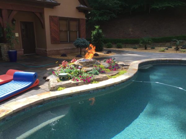 A striking fire bowl illuminating the pool area, casting a warm glow over the serene waters.
