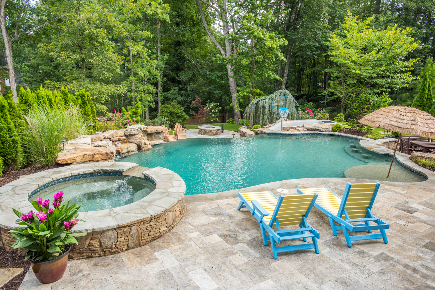 A custom freeform pool with a spa and swim-up bar surrounded by lounge chairs.
