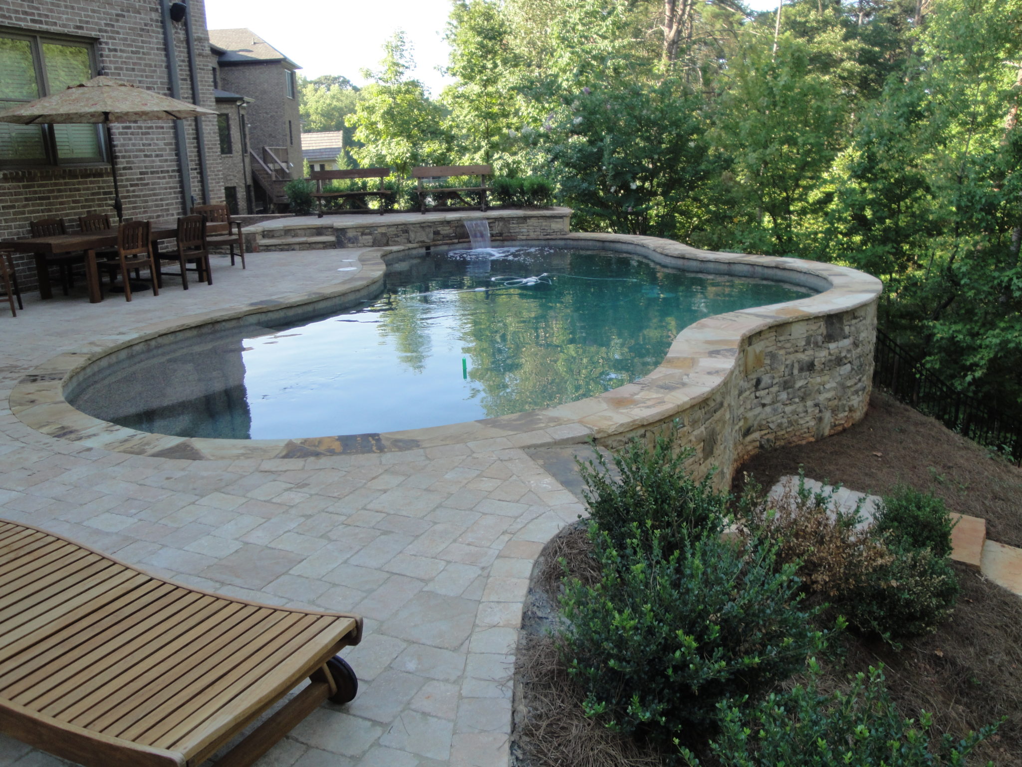 A sleek and stylish modern freeform pool design.