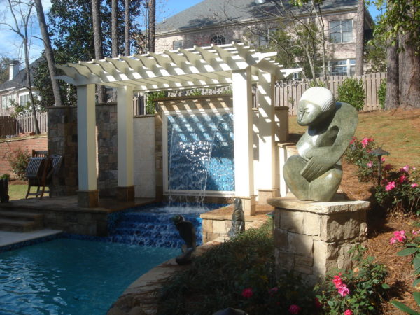 A stunning swimming pool adorned with a pergola, featuring tiered spillover for a captivating visual experience