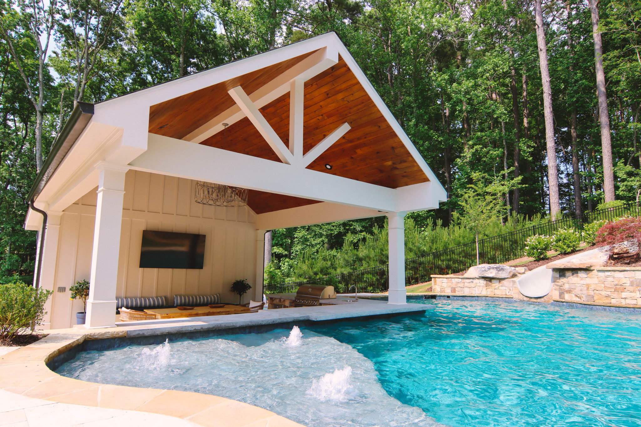 A serene vaulted sunken cabana nestled beside a sparkling swimming pool, offering a peaceful retreat.