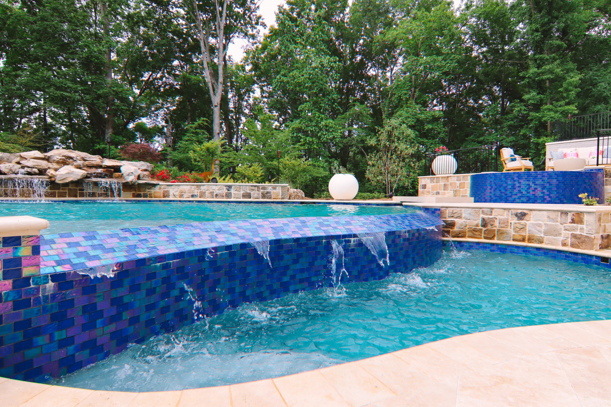 Custom blue tile vanishing edge pool with scenic view