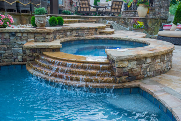 A serene circular spa with tiered spillover, offering a picturesque and relaxing addition to your outdoor haven.