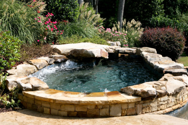 A serene spa nestled among natural boulders, offering a rustic and picturesque addition to your outdoor oasis.