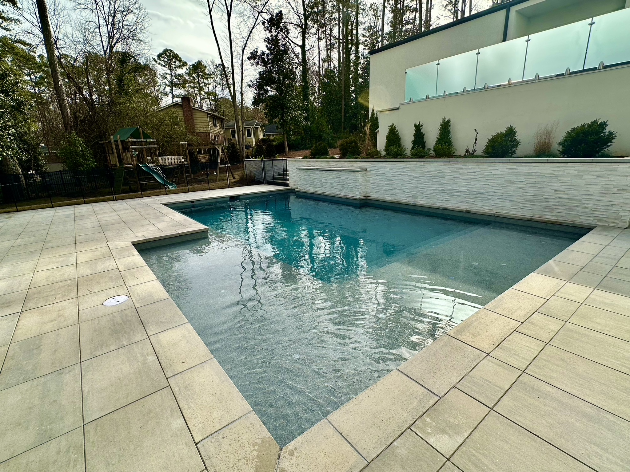 A contemporary straight-line pool surrounded by urban architecture.