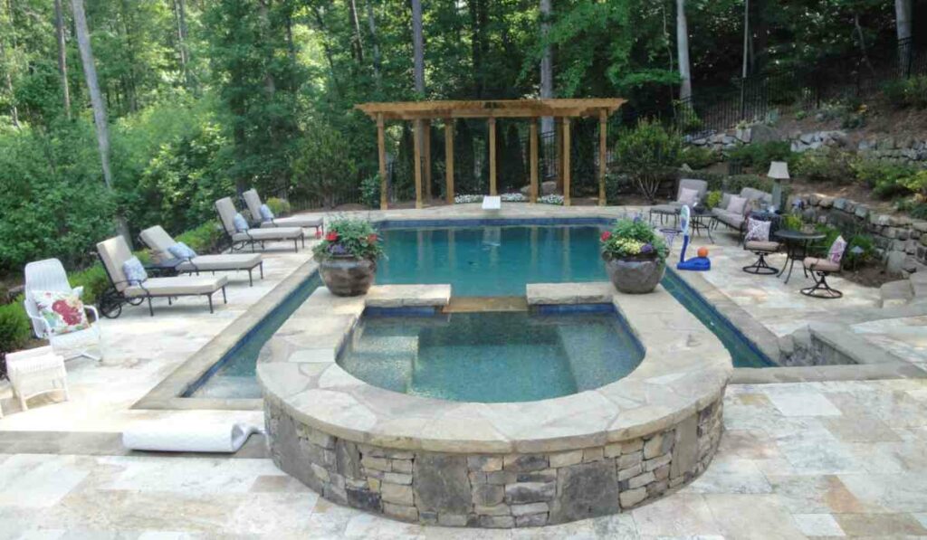 A Luxurious Pool With a Natural Stone Wall And Inviting Chairs