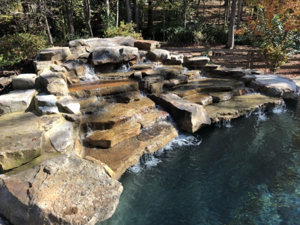 indulge in the serenity of our custom three-tier boulder waterfall pool.