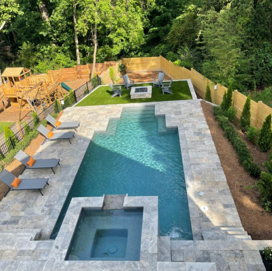 A Pool With A Fire Pit And Chairs