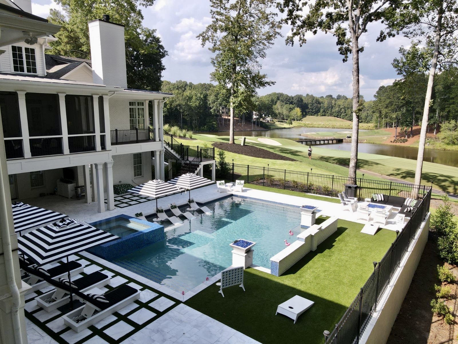 Elegant modern swimming pool with clean lines and a 360-degree spa, designed with glass tile accents at Hawks Ridge