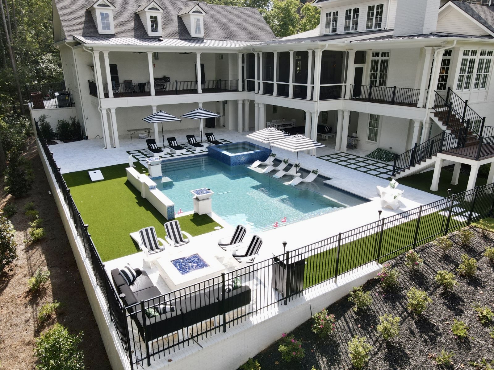 Elegant modern swimming pool with clean lines and a 360-degree spa, designed with glass tile accents at Hawks Ridge