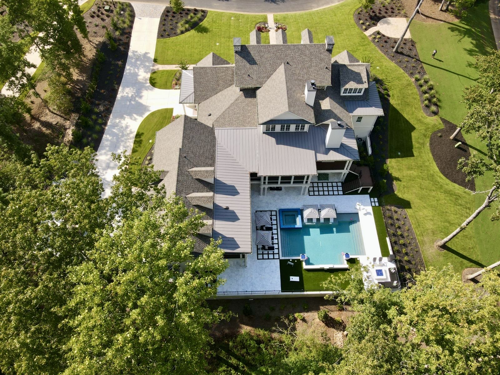 Elegant modern swimming pool with clean lines and a 360-degree spa, designed with glass tile accents at Hawks Ridge