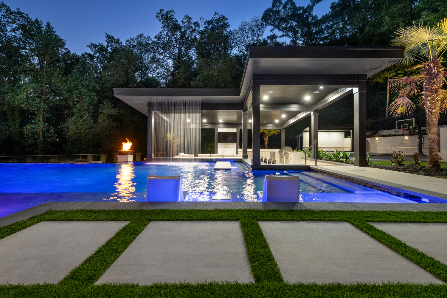 Modern cabana with integrated outdoor kitchen in Grady Jarrett's luxurious backyard, designed by Georgia Classic Pool.