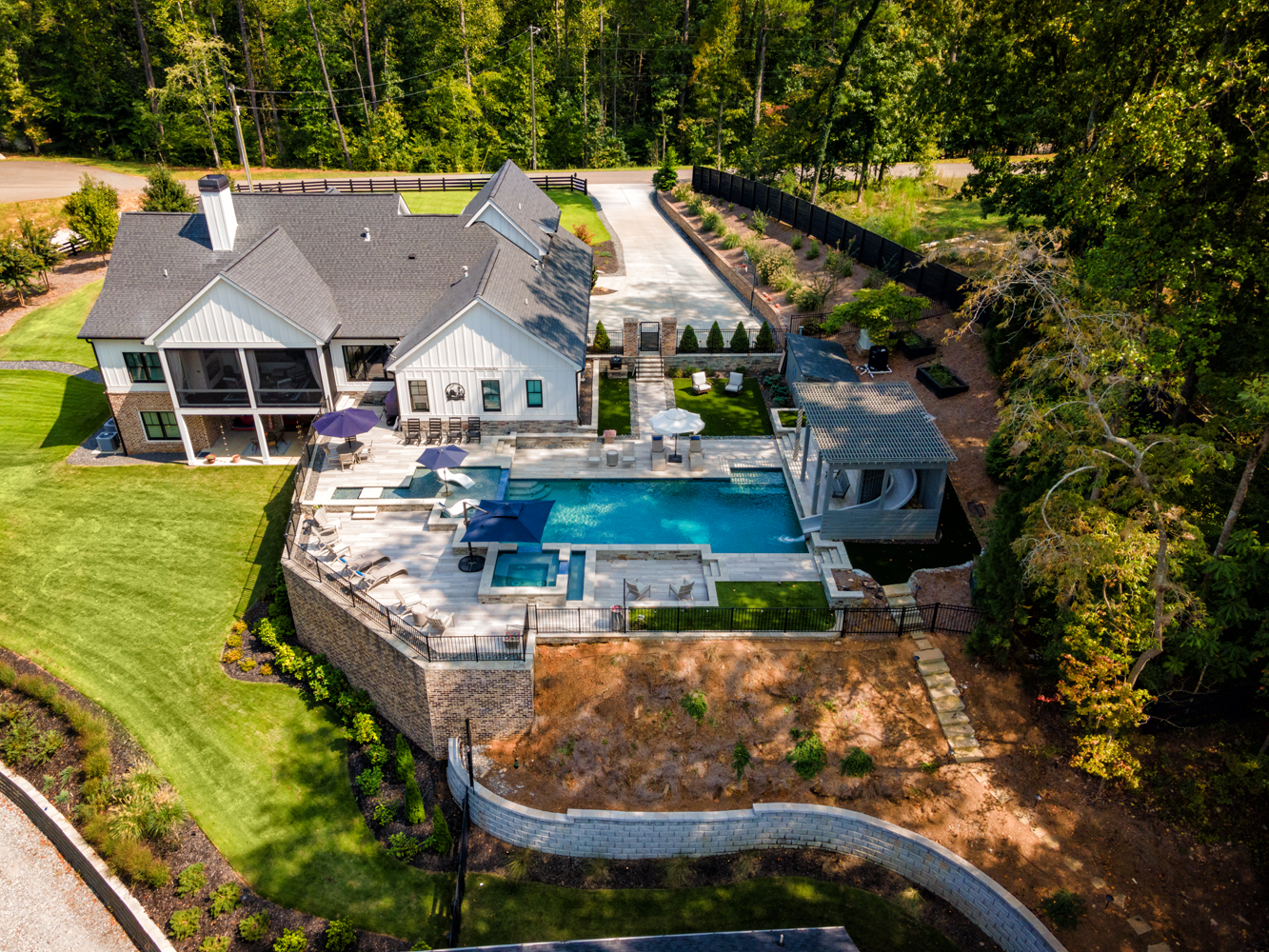 Elegant multi-level swimming pool with infinity edge, spa, and large tanning shelf at Iron Mountain, designed by Georgia Classic Pool