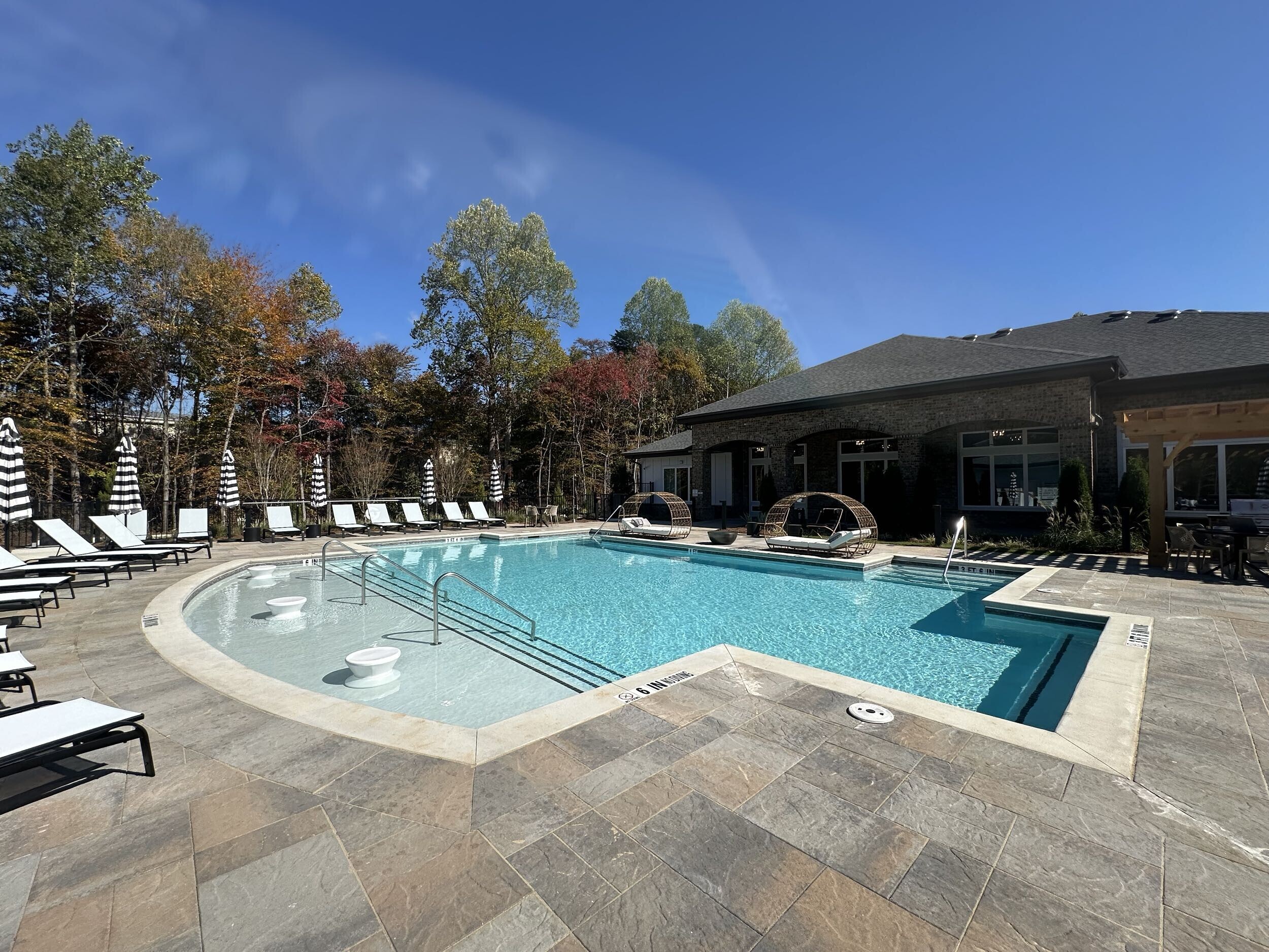 A beautiful neighborhood apartment complex pool in Gainesville, designed and built by Georgia Classic Pool, featuring a large, inviting swimming area surrounded by modern landscaping and comfortable lounge seating.