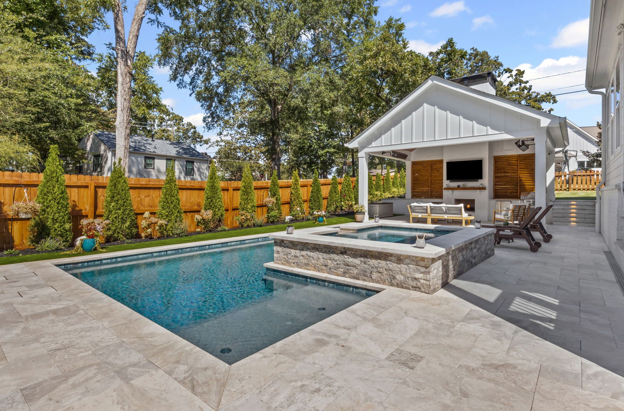 Modern pool with cabana, outdoor fireplace, and professionally designed landscape